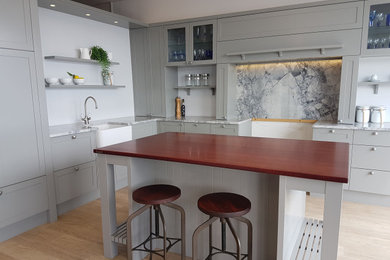 Exemple d'une cuisine ouverte chic en L de taille moyenne avec un plan de travail en bois, îlot et un plan de travail rouge.
