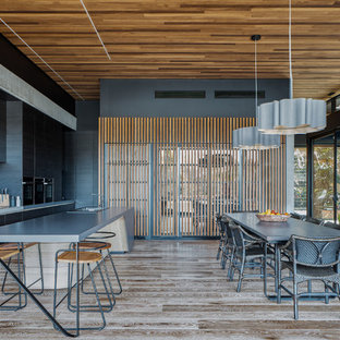 This is an example of a contemporary galley eat-in kitchen in Gold Coast - Tweed with a drop-in sink, flat-panel cabinets, black cabinets, grey splashback, mosaic tile splashback, medium hardwood floors, with island, brown floor and grey benchtop.