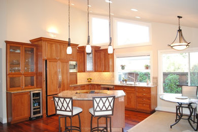 Example of a mid-sized transitional l-shaped medium tone wood floor eat-in kitchen design in San Francisco with an island, an undermount sink, recessed-panel cabinets, medium tone wood cabinets, granite countertops, white backsplash, subway tile backsplash and stainless steel appliances