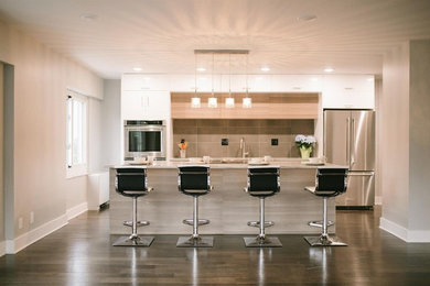 Foto på ett mellanstort funkis linjärt kök med öppen planlösning, med en rustik diskho, släta luckor, vita skåp, granitbänkskiva, grått stänkskydd, stänkskydd i keramik, rostfria vitvaror, mörkt trägolv, en köksö och brunt golv