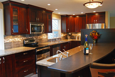 Exempel på ett stort klassiskt kök och matrum, med en undermonterad diskho, skåp i shakerstil, skåp i mörkt trä, granitbänkskiva, grått stänkskydd, stänkskydd i mosaik, rostfria vitvaror, klinkergolv i porslin och en köksö