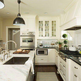 Traditional kitchen in Minneapolis with an undermount sink, glass-front cabinets, white cabinets, white splashback, subway tile splashback, stainless steel appliances, dark hardwood floors and with island.
