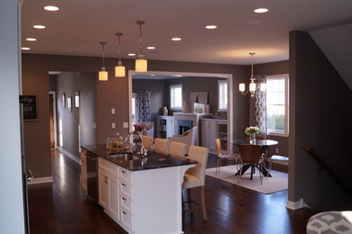 Example of a large classic single-wall dark wood floor open concept kitchen design in Minneapolis with an undermount sink, shaker cabinets, white cabinets, granite countertops, white backsplash, subway tile backsplash, stainless steel appliances and an island