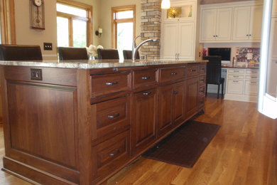 Example of a mid-sized classic galley medium tone wood floor eat-in kitchen design in Minneapolis with a double-bowl sink, beaded inset cabinets, white cabinets, granite countertops, beige backsplash, ceramic backsplash and stainless steel appliances