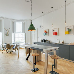 Design ideas for a large bohemian open plan kitchen in Edinburgh with laminate countertops, an island, grey worktops, a single-bowl sink, flat-panel cabinets, grey cabinets, light hardwood flooring and beige floors.