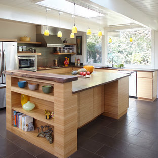 Ispirazione per una cucina moderna di medie dimensioni con ante lisce, ante in legno chiaro, paraspruzzi grigio, elettrodomestici in acciaio inossidabile, lavello sottopiano, top in legno, paraspruzzi in lastra di pietra, pavimento in gres porcellanato, pavimento nero e top marrone