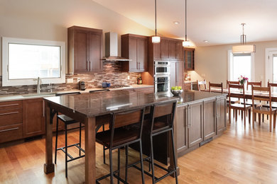 Mid-sized transitional galley medium tone wood floor and brown floor eat-in kitchen photo in Denver with an undermount sink, shaker cabinets, medium tone wood cabinets, granite countertops, multicolored backsplash, mosaic tile backsplash, stainless steel appliances, two islands and gray countertops