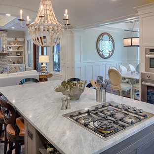 This is an example of a mid-sized country l-shaped eat-in kitchen in Grand Rapids with a double-bowl sink, recessed-panel cabinets, white cabinets, marble benchtops, stainless steel appliances, dark hardwood floors and with island.