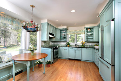 Exempel på ett mellanstort amerikanskt kök, med rostfria vitvaror, skåp i shakerstil, blå skåp, granitbänkskiva, en undermonterad diskho, flerfärgad stänkskydd, stänkskydd i glaskakel och ljust trägolv