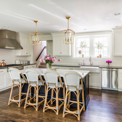 Kitchen - large transitional u-shaped dark wood floor and brown floor kitchen idea in Philadelphia with a farmhouse sink, white cabinets, quartz countertops, white backsplash, ceramic backsplash, stainless steel appliances, an island and shaker cabinets
