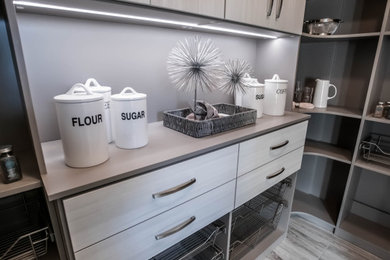 ラスベガスにあるラグジュアリーな広いコンテンポラリースタイルのおしゃれなキッチン (白いキャビネット、木材カウンター、白いキッチンパネル、白い調理設備、グレーのキッチンカウンター) の写真