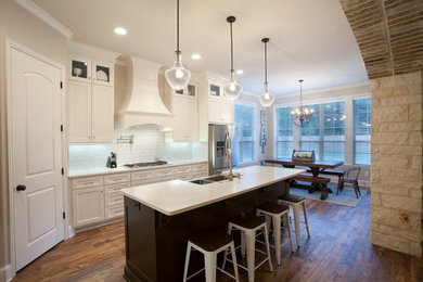 Inspiration for a large contemporary l-shaped porcelain tile eat-in kitchen remodel in Austin with a farmhouse sink, shaker cabinets, white cabinets, quartzite countertops, white backsplash, ceramic backsplash, stainless steel appliances and an island