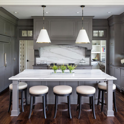 Example of a transitional u-shaped dark wood floor and brown floor eat-in kitchen design in Minneapolis with an undermount sink, recessed-panel cabinets, gray cabinets, white backsplash, stone slab backsplash, paneled appliances, an island and white countertops
