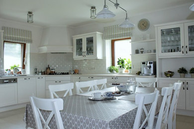 Design ideas for a large traditional u-shaped kitchen/diner in Other with a triple-bowl sink, glass-front cabinets, white cabinets, white splashback, metro tiled splashback and ceramic flooring.