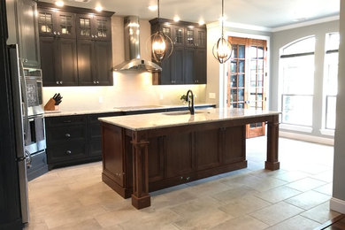 Transitional l-shaped porcelain tile and gray floor kitchen photo in Little Rock with an undermount sink, granite countertops, white backsplash, ceramic backsplash, stainless steel appliances and an island