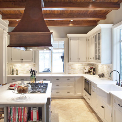 Inspiration for a mid-sized timeless u-shaped limestone floor eat-in kitchen remodel in Charleston with shaker cabinets, a farmhouse sink, white cabinets, marble countertops, beige backsplash, matchstick tile backsplash, stainless steel appliances and an island
