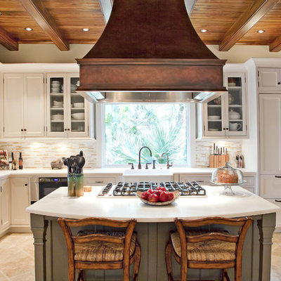 Eat-in kitchen - mid-sized traditional u-shaped limestone floor eat-in kitchen idea in Charleston with shaker cabinets, a farmhouse sink, white cabinets, marble countertops, beige backsplash, matchstick tile backsplash, stainless steel appliances and an island