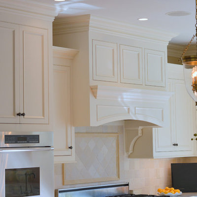 Large elegant u-shaped medium tone wood floor and brown floor eat-in kitchen photo in New York with an undermount sink, beaded inset cabinets, white cabinets, quartzite countertops, beige backsplash, stone tile backsplash, paneled appliances and an island