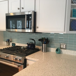 Inspiration for a traditional l-shaped eat-in kitchen in Providence with a double-bowl sink, recycled glass benchtops, green splashback, glass tile splashback, stainless steel appliances and a peninsula.