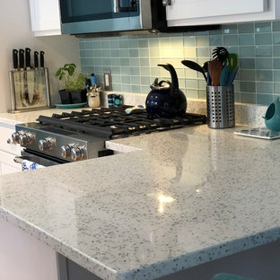 Photo of a traditional l-shaped eat-in kitchen in Providence with a double-bowl sink, recycled glass benchtops, green splashback, glass tile splashback, stainless steel appliances and a peninsula.