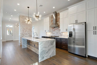 Large transitional single-wall medium tone wood floor and brown floor kitchen photo in New Orleans with an undermount sink, shaker cabinets, white cabinets, quartzite countertops, red backsplash, brick backsplash, stainless steel appliances, an island and white countertops
