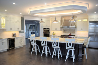 Example of a large classic single-wall medium tone wood floor eat-in kitchen design in Toronto with an undermount sink, flat-panel cabinets, white cabinets, granite countertops, subway tile backsplash, stainless steel appliances, an island and multicolored countertops