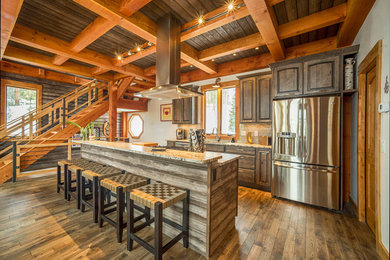 Large mountain style dark wood floor kitchen photo in Denver with an undermount sink, raised-panel cabinets, dark wood cabinets, granite countertops, an island, beige backsplash, subway tile backsplash, stainless steel appliances and multicolored countertops