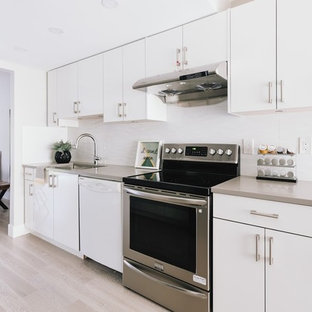 Photo of a mid-sized modern single-wall eat-in kitchen in Vancouver with a drop-in sink, flat-panel cabinets, white cabinets, solid surface benchtops, white splashback, stone tile splashback, plywood floors, no island, brown floor and brown benchtop.