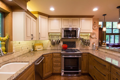 Eat-in kitchen - small traditional u-shaped medium tone wood floor eat-in kitchen idea in Milwaukee with an undermount sink, raised-panel cabinets, medium tone wood cabinets, quartz countertops, beige backsplash, porcelain backsplash, stainless steel appliances and a peninsula