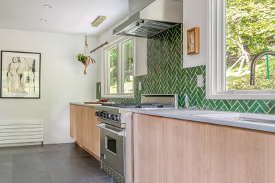 Mid-sized farmhouse galley slate floor and gray floor kitchen photo in New York with a drop-in sink, flat-panel cabinets, light wood cabinets, green backsplash, ceramic backsplash, stainless steel appliances, no island and gray countertops