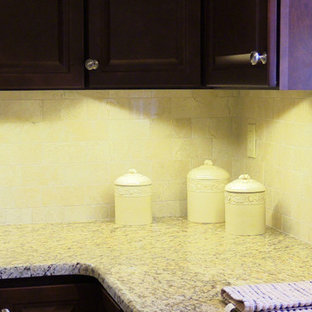 Small u-shaped separate kitchen in Baltimore with a single-bowl sink, raised-panel cabinets, dark wood cabinets, granite benchtops, beige splashback, porcelain splashback, stainless steel appliances, porcelain floors and no island.
