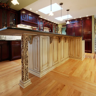 Large transitional eat-in kitchen ideas - Example of a large transitional light wood floor eat-in kitchen design in Chicago with a farmhouse sink, raised-panel cabinets, red cabinets, granite countertops, metallic backsplash, metal backsplash, stainless steel appliances and an island