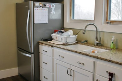 Foto på ett avskilt, mellanstort l-kök, med en undermonterad diskho, släta luckor, vita skåp, bänkskiva i kvarts, rostfria vitvaror och vinylgolv