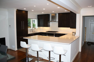 Inspiration for a mid-sized modern l-shaped dark wood floor open concept kitchen remodel in DC Metro with an undermount sink, flat-panel cabinets, dark wood cabinets, quartz countertops, white backsplash, subway tile backsplash, stainless steel appliances and a peninsula