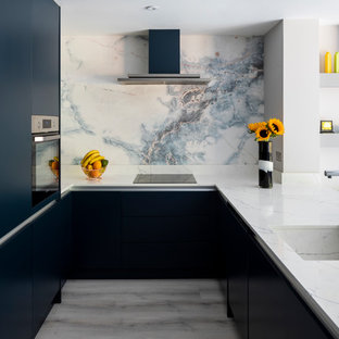 Inspiration for a medium sized contemporary u-shaped kitchen in London with a submerged sink, flat-panel cabinets, blue cabinets, marble worktops, white splashback, marble splashback, stainless steel appliances, no island, grey floors and white worktops.