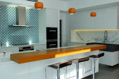 メルボルンにある広いコンテンポラリースタイルのおしゃれなキッチン (ダブルシンク、白いキャビネット、珪岩カウンター、青いキッチンパネル、セメントタイルのキッチンパネル、シルバーの調理設備) の写真