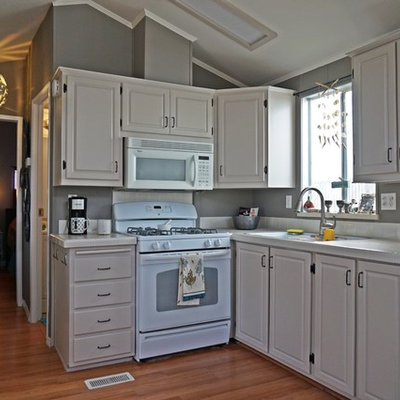 Inspiration for a small contemporary l-shaped medium tone wood floor eat-in kitchen remodel in San Diego with an undermount sink, raised-panel cabinets, white cabinets, tile countertops, white backsplash, porcelain backsplash, white appliances and no island