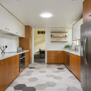 Photo of a mid-sized midcentury u-shaped separate kitchen in Los Angeles with an undermount sink, flat-panel cabinets, medium wood cabinets, quartz benchtops, white splashback, porcelain splashback, stainless steel appliances, porcelain floors, white benchtop, no island and grey floor.
