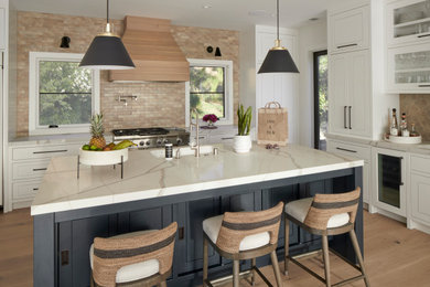 Inspiration for a farmhouse l-shaped light wood floor open concept kitchen remodel in San Francisco with an undermount sink, flat-panel cabinets, white cabinets, quartz countertops, beige backsplash, ceramic backsplash, paneled appliances, an island and white countertops