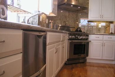 Example of a mid-sized classic l-shaped medium tone wood floor open concept kitchen design in San Francisco with an undermount sink, raised-panel cabinets, white cabinets, granite countertops, stone slab backsplash, stainless steel appliances and an island