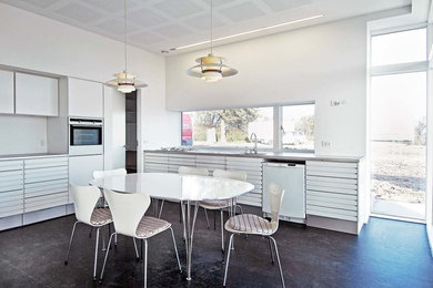 Medium sized contemporary l-shaped kitchen/diner in Esbjerg with white cabinets.