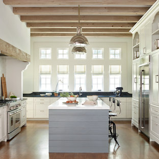 Transitional kitchen designs - Transitional medium tone wood floor kitchen photo in Atlanta with shaker cabinets, white cabinets, stainless steel appliances and an island