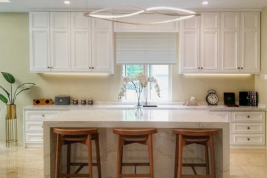 Example of a mid-sized minimalist single-wall limestone floor and beige floor enclosed kitchen design in Other with a drop-in sink, beaded inset cabinets, white cabinets, marble countertops, an island and white countertops