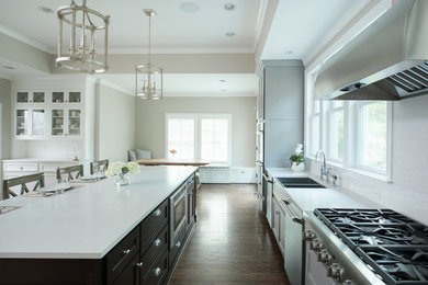 Eat-in kitchen - large farmhouse l-shaped dark wood floor eat-in kitchen idea in Kansas City with a farmhouse sink, shaker cabinets, white backsplash, subway tile backsplash, stainless steel appliances, an island and gray cabinets