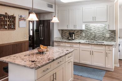 Mid-sized transitional l-shaped light wood floor open concept kitchen photo in Miami with an undermount sink, shaker cabinets, white cabinets, granite countertops, green backsplash, mosaic tile backsplash, stainless steel appliances and an island