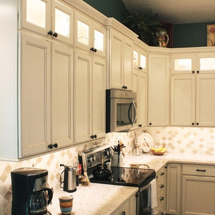 Inspiration for a mid-sized country l-shaped eat-in kitchen in Boise with a farmhouse sink, recessed-panel cabinets, beige cabinets, quartz benchtops, beige splashback, mosaic tile splashback, stainless steel appliances, vinyl floors, with island and brown floor.