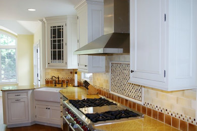 Eat-in kitchen - mid-sized traditional u-shaped medium tone wood floor eat-in kitchen idea in New York with a farmhouse sink, beaded inset cabinets, white cabinets, granite countertops, beige backsplash, ceramic backsplash, stainless steel appliances and an island
