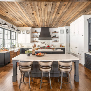 Esempio di una cucina ad U country con lavello stile country, ante in stile shaker, ante grigie, elettrodomestici in acciaio inossidabile, parquet scuro, 2 o più isole, pavimento marrone e top bianco
