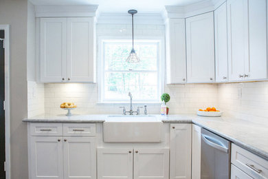 Example of a mid-sized minimalist dark wood floor and brown floor eat-in kitchen design in Other with shaker cabinets, white cabinets, marble countertops, white backsplash, subway tile backsplash and a farmhouse sink