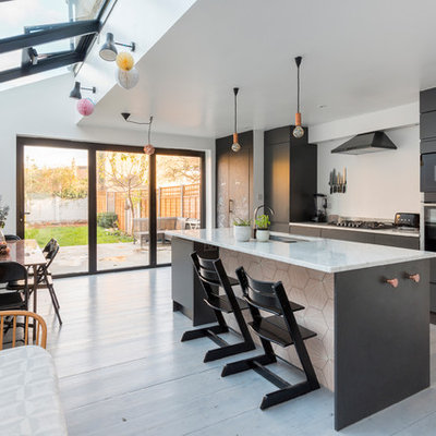 Eat-in kitchen - mid-sized contemporary single-wall light wood floor and white floor eat-in kitchen idea in London with flat-panel cabinets, black cabinets, marble countertops and an island